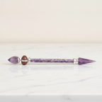 Amethyst shiva lingam wand with silver collars, lying on cotton-rag paper - view 2