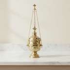 Ornate brass hanging incense burner standing on its footed base, chains beside it - view 2