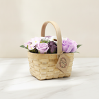 Lilac and purple soap roses in a woven wicker basket with a tag, on cotton-rag paper