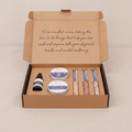 Dark self-care kit box lying flat and closed on rumpled linen