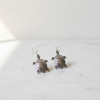 A pair of sterling silver turtle drop earrings on cotton canvas - view 2