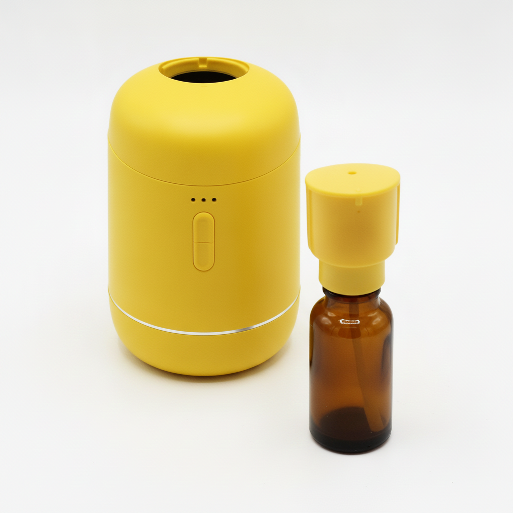 Yellow waterless diffuser open beside a 20ml amber oil bottle fitted with its yellow nozzle