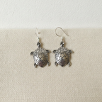 A pair of sterling silver turtle drop earrings on cotton canvas - view 3