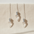 Three clear quartz pendulums with silver caps hanging from fine chains - view 3