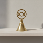 Triple moon brass altar bell on a painted wooden shelf