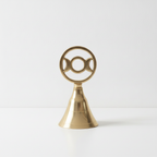 Triple moon brass altar bell on a plain white surface