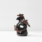 Dolphin wave backflow incense burner on a white surface
