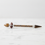 Tiger eye shiva lingam crystal wand lying on marble