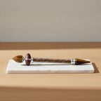 Tiger eye shiva lingam crystal wand on a marble board, oak table